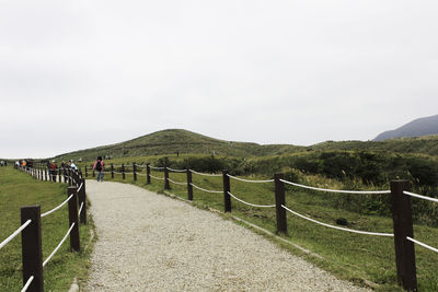 View of fence on landscape against sky