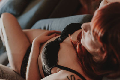 Close-up of sensuous woman relaxing on bed at home