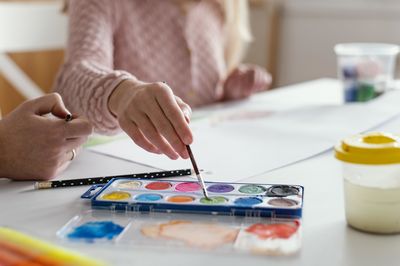 Midsection of woman painting on table