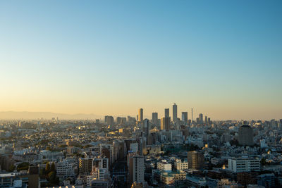 Aerial view of city buildings against clear sky