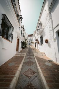 Low angle view of alley amidst buildings in city