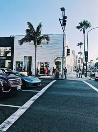 Cars on street in city against clear sky