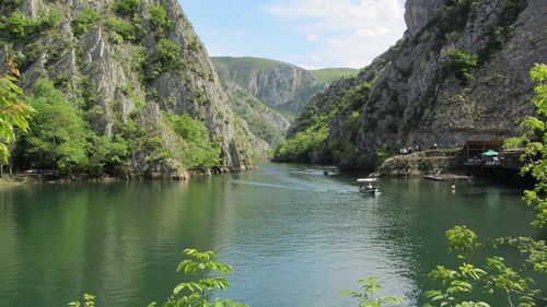 Scenic view of river and mountains against sky