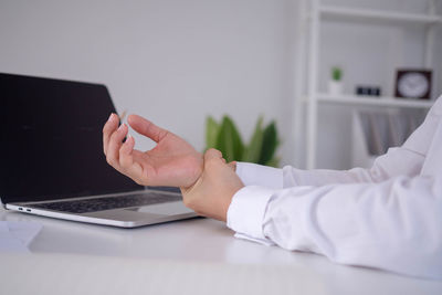 Midsection of man using laptop on table