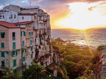 Panoramic view of sea and buildings against sky during sunset