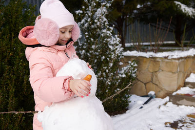 Rear view of woman standing in snow