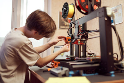 Side view of boy holding camera