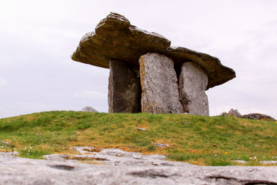 Stone structure on field against sky