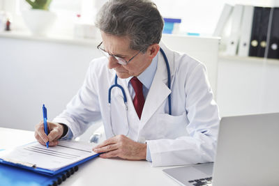 Midsection of man using laptop on table