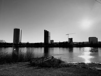 River by buildings against clear sky