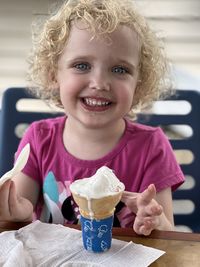 Little girl eating ice cream outside at ice cream shop