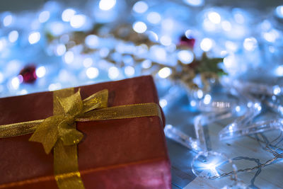 Christmas present with illuminated decorations on table