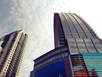 Low angle view of buildings against cloudy sky