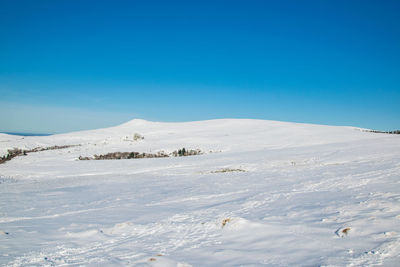 Scenic view of snowcapped mountains against blue sky