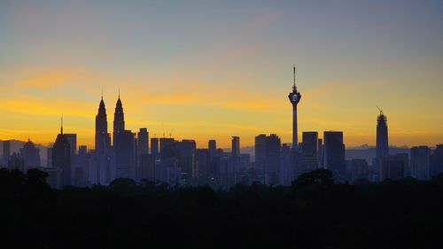 Skyscrapers in city at sunset