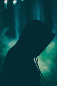 Close-up portrait of silhouette person in hat