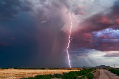 Lightning over landscape against storm clouds