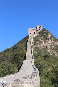 Castle on mountain against blue sky