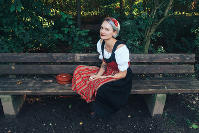 Portrait of smiling woman sitting on bench