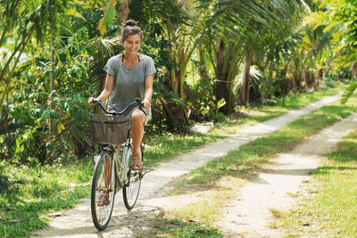 Rear view of man riding bicycle on road