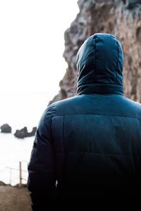 Rear view of man standing against sky during winter