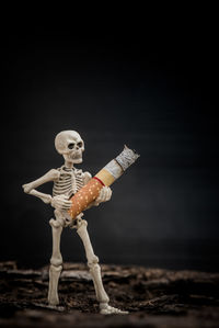 Person with toy figurine on wood against black background