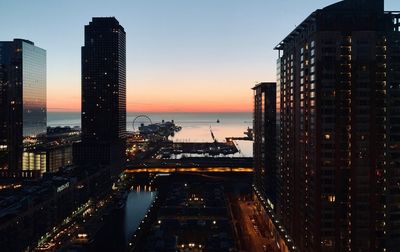 High angle view of illuminated buildings by street against sky during sunset