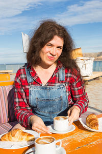 Smiling woman with drink on table