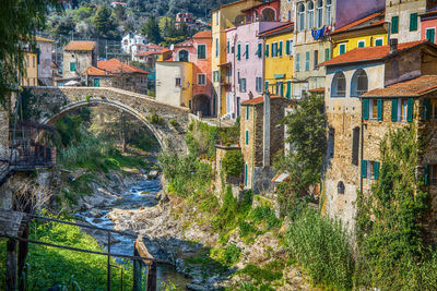 Arch bridge over river amidst buildings in town