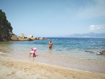 People on beach against clear sky