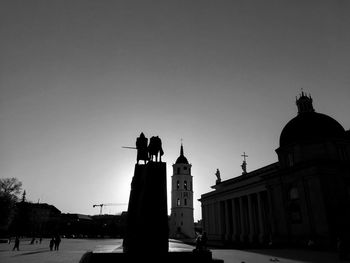 Silhouette of statues on building against sky