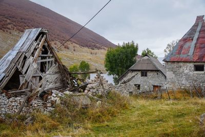 Abandoned house on field against sky