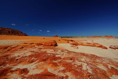 Scenic view of desert against clear blue sky