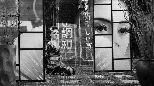 Reflection of man sitting on glass window