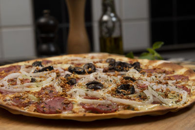 Brazilian pizza with pepperoni, cheese, onion and black olive , top view