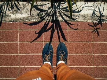 Low section of person standing on tiled floor