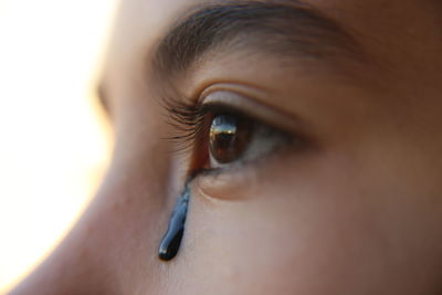 Close-up of teenage girl with black teardrop