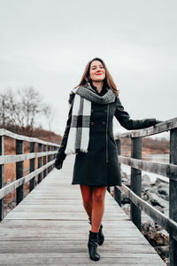 Full length of woman standing on footbridge