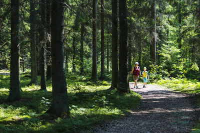 Mother with son walking through forest