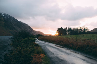 View of country road against cloudy sky