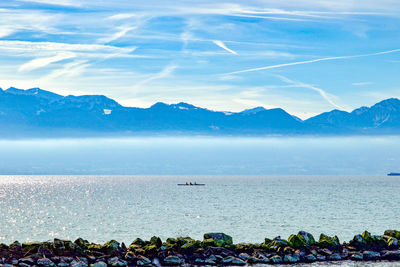 Scenic view of sea and mountains against sky