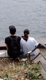 Rear view of man sitting in river