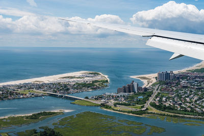 Airplane flying over sea against sky