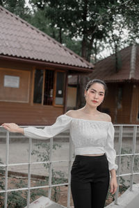 Portrait of woman standing against building