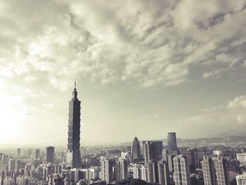 Cityscape against cloudy sky