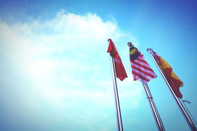 Low angle view of flags against blue sky