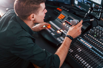 Setting the equipment. young man is indoors in the radio studio is busy by broadcast.