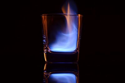Close-up of fire in glass against black background