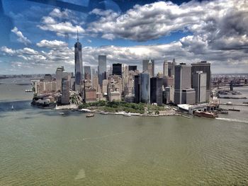 Skyscrapers in city against cloudy sky