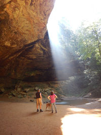 Rear view of people walking on road amidst trees
